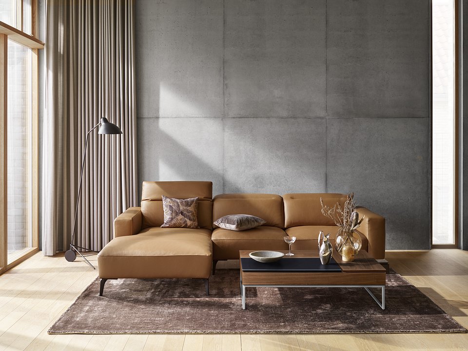Sofa Zürich z szezlongiem, cena 10.666,-<br>Stolik kawowy Chiva ze schowkami, cena od 2.759,-<br>Lampa podłogowa Demand, cena 3.239,-<br>Dywan Simple, cena od 4.242,-