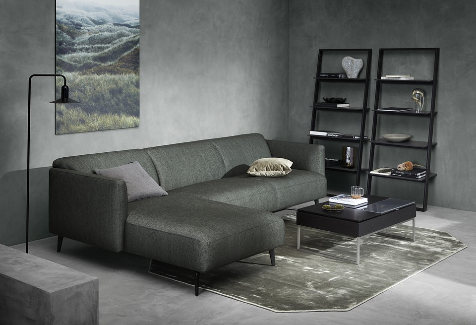Sofa Modena z szezlongiem, cena od 5.990,-<br>Stolik kawowy Chiva ze schowkami, cena od 2.759,-<br>Regał ścienny Bordeaux, cena 2.190,-<br>Lampa podłogowa Aerial, cena 3.429,-<br>Obraz na metali North sea hills, cena 1.659,-<br>Dywan Shanghai, cena od 2.569,-