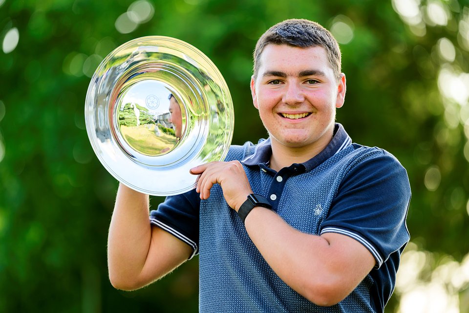 Alex Wells holds the English Under 18 Championship trophy at Effingham Golf Club in Surrey.