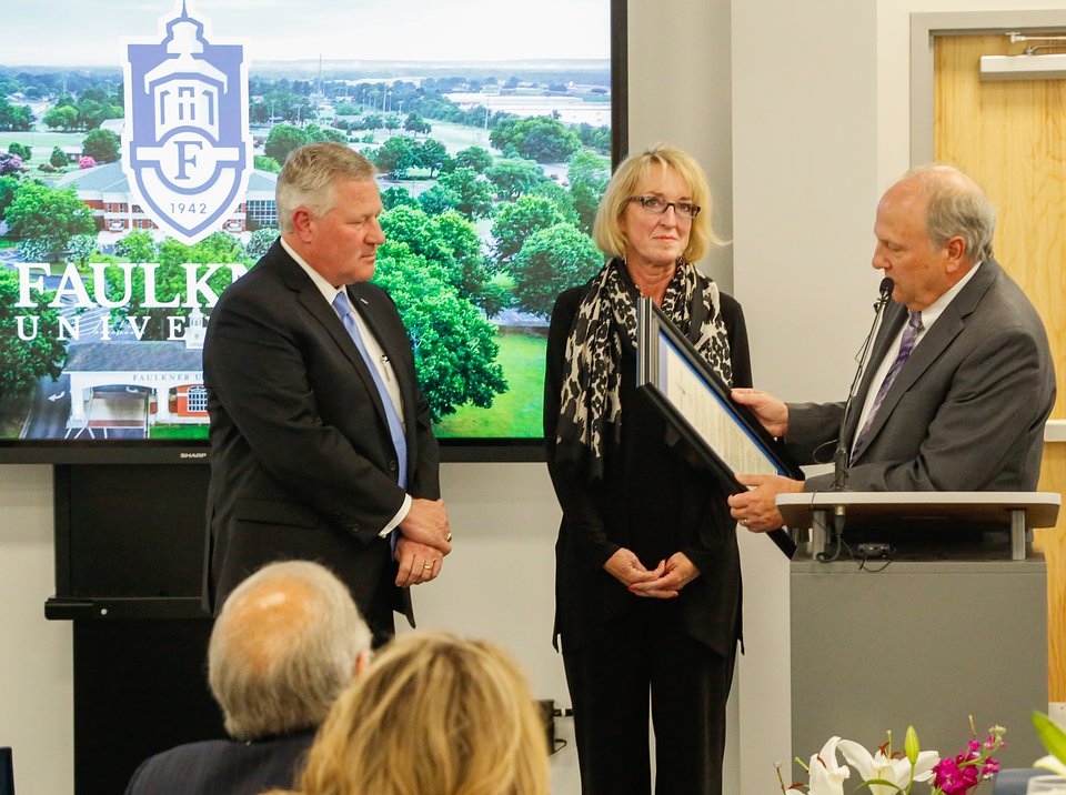 Dale Kirkland, right, reads the resolution to Mike and Lisa Williams, to name the autism center the Mike and Lisa Williams Center of Autism.