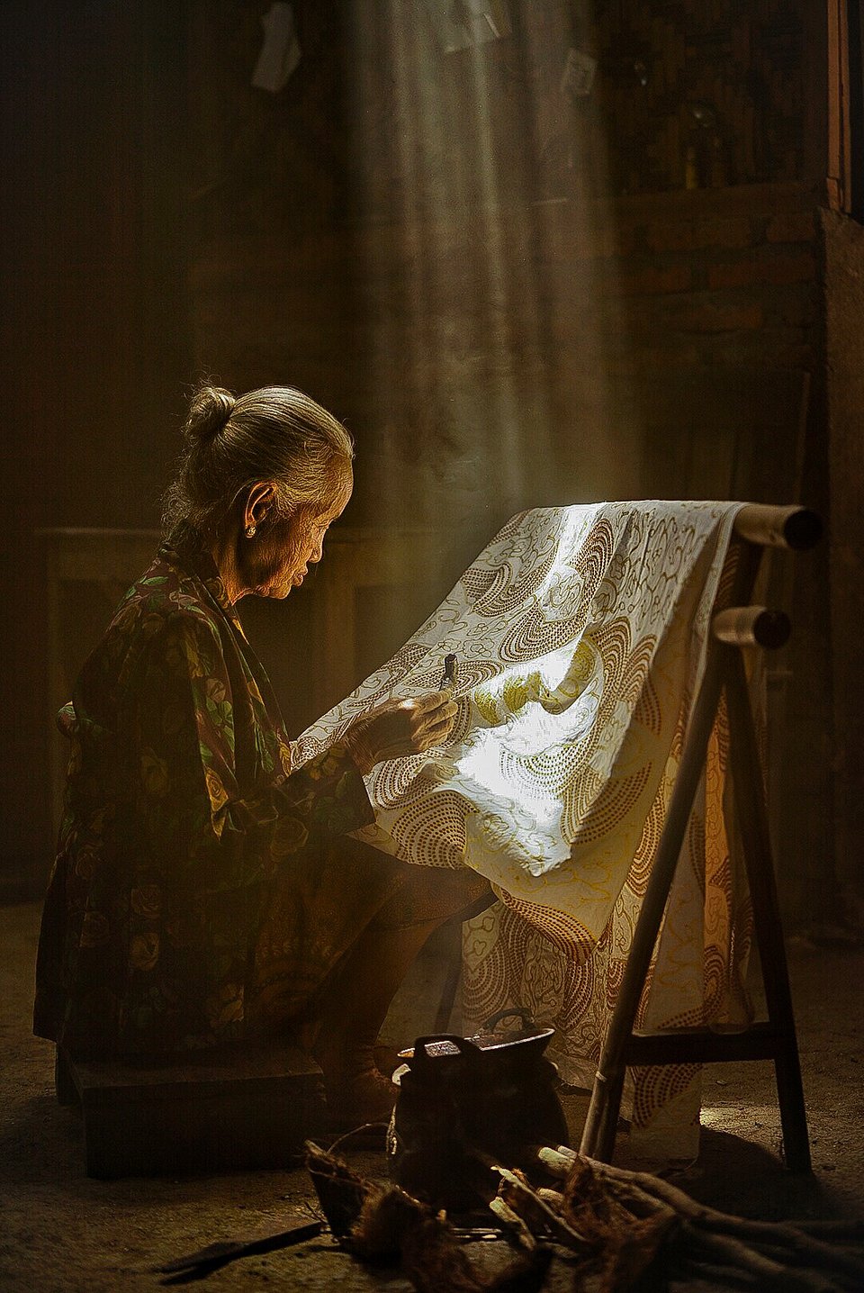 As the sunlight gets through the ceiling, this woman completes her Batik painting, one of Indonesia's most ancient craft (Lety Liza/AGORA images)